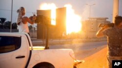 A fighter under the UN-backed government fires an Anti-aircraft gun during clashes in Wadi Alrabie south Tripoli, Sept. 21, 2018.