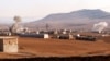 FILE - Smoke rises from bombardment amid battles between the Turkish-backed Syrian National Army faction and the Kurdish-led Syrian Democratic Forces at a position near the Tishrin Dam in the vicinity of Manbij, in the east of Syria's northern Aleppo province, Jan. 10, 2025. 