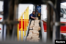 Bahraini officials load medical aid and ground-support equipment into a plane as they head to Beirut to provide support following Tuesday's blast, at Isa Air Base in Ras Al Bur, Bahrain, Aug. 7, 2020.