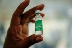 FILE - In this March 24, 2021, file photo, a nurse holds a vial of the AstraZeneca COVID-19 vaccine, manufactured by the Serum Institute of India and provided through the global COVAX initiative, prior to vaccination in Machakos, Kenya.