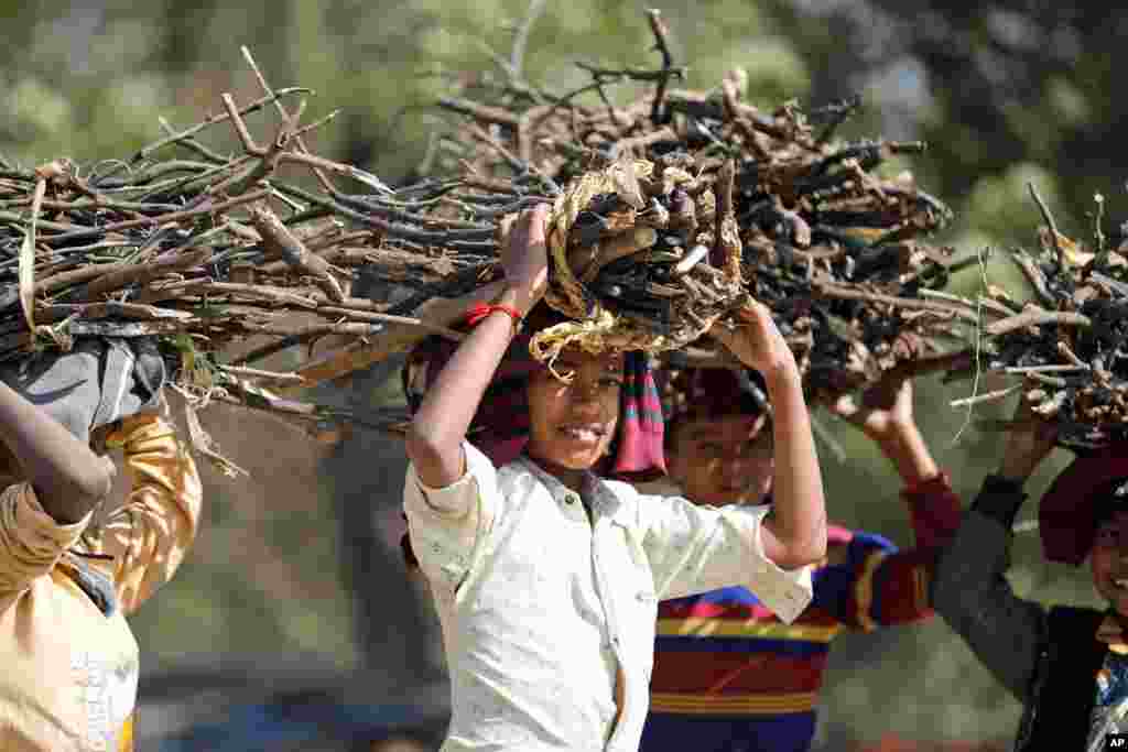 Children carry firewood on their heads on the outskirts of Rae Bareli, India.