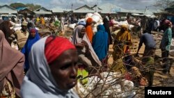 FILE - Somali refugees organize their collected ration of food during a distribution exercise outside a United Nations World Food Program center at a refugee settlement in Dadaab, Kenya, October 2013.