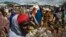 FILE - Somali refugees organize their collected ration of food during a distribution exercise outside a United Nations World Food Program center at a refugee settlement in Dadaab, Kenya, October 2013.