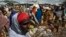 FILE - Somali refugees organize their collected ration of food during a distribution exercise outside a United Nations World Food Program center at a refugee settlement in Dadaab, Kenya, October 2013.