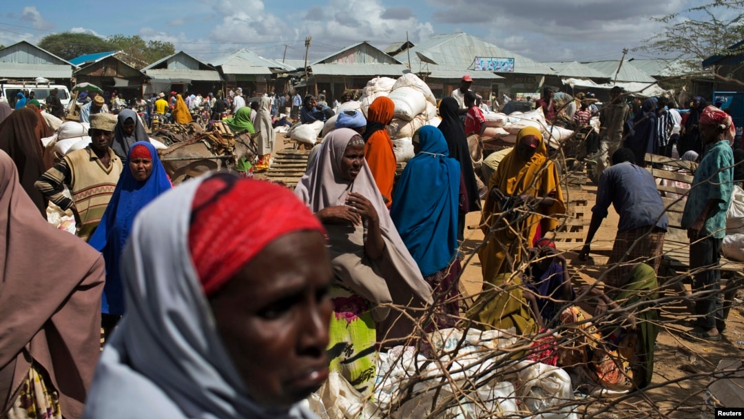 FILE - Somali refugees organize their food rations during a distribution exercise outside a U.N. World Food Program center at the Dadaab refugee settlement in Kenya, October 2013.