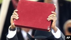 South Sudan's President Salva Kiir holds aloft the country's transitional constitution after signing it into law during Independence Day celebrations in Juba, July 9, 2011. (AP)