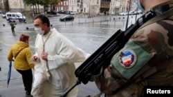 A French soldier stands guard in front of the cathedral in Cambrai during the All Saints Day mass, as the country has raised the security alert for its territory to the highest level after the knife attack in the city of Nice, Nov. 1, 2020.