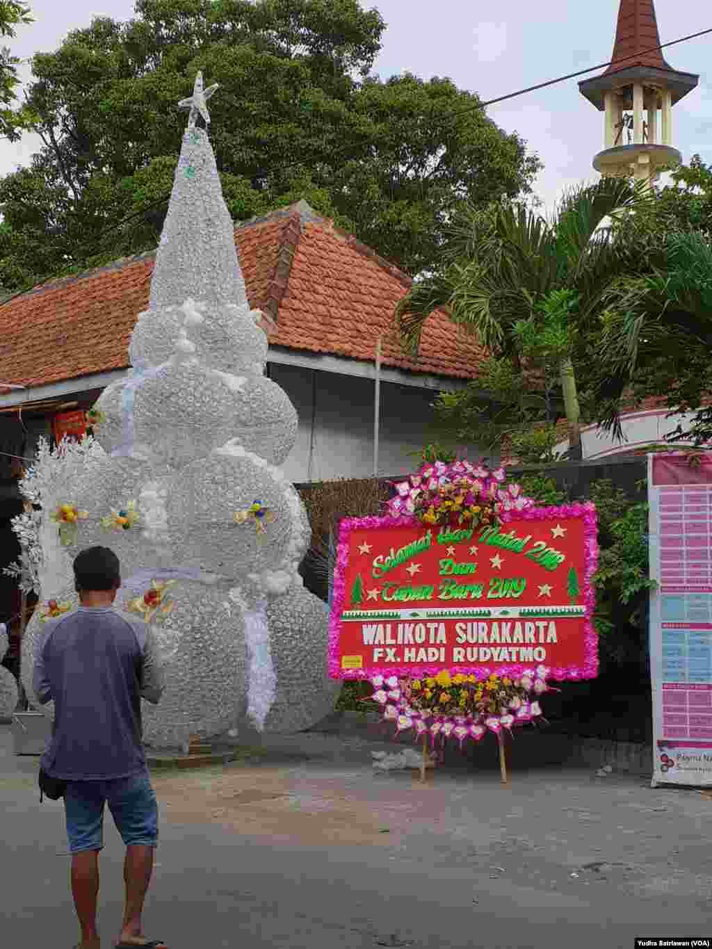 Pohon Natal setinggi 6 meter dari 9.000 botol plastik bekas kemasan air mineral terpajang di depan Gereja Santa Perawan Maria Regina Purbowardayan, Solo, 24 Desember 2018. (Foto: Yudha Satriawan/VOA)