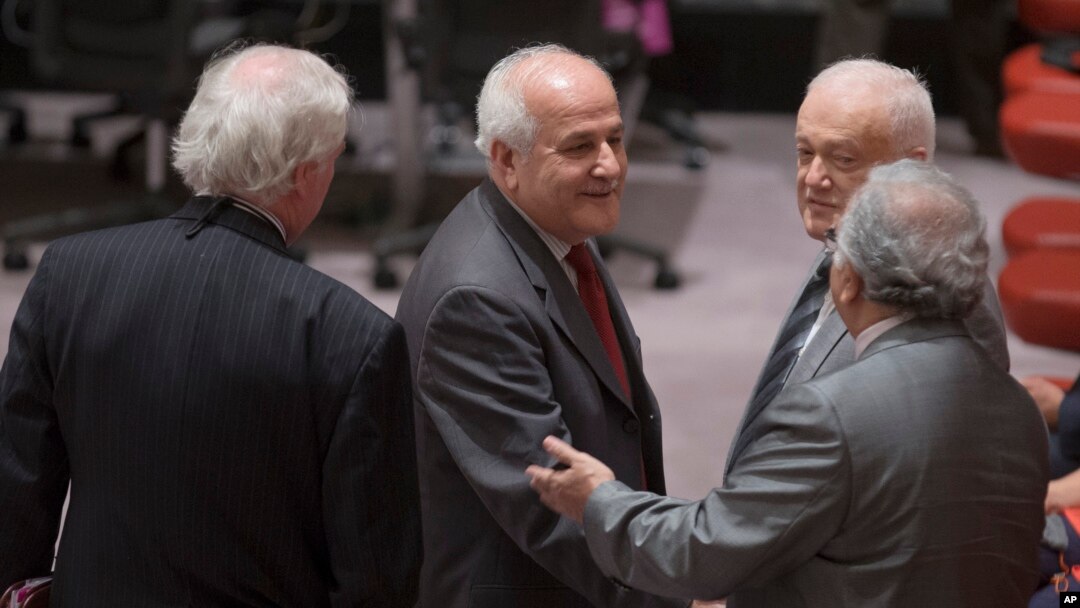FILE - Palestinian U.N. representative Riyad Mansour, center, greets fellow diplomats before a meeting of the U.N. Security Council in New York, July 28, 2014.