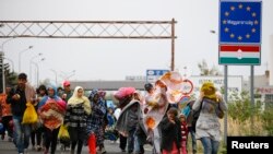 FILE - Migrants walk as they cross the border from Hungary to Nickelsdorf, Austria, September 25, 2015. Austria, Germany, Denmark, Sweden, and Norway will be allowed to continue their controls for six months, the European Council decided with immediate effect Thursday.