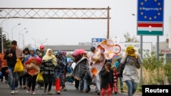 Para migran berjalan melintasi perbatasan dari Hungaria ke Nickelsdorf, Austria, 25 September 2015 (Foto: dok).