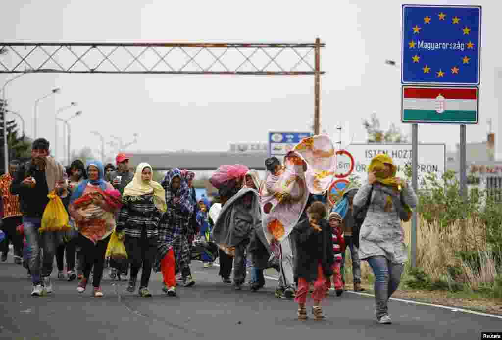 Migrants walk as they cross the border from Hungary to Nickelsdorf, Austria, September 25, 2015. The United Nations said on Friday it could see no easing of the flow of refugees into Europe, with 8,000 arrivals daily.