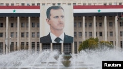 Foto Presiden Suriah Bashar al-Assad terlihat di gedung Bank Sentral Suriah di Damaskus (foto: dok). AS mengumumkan sanksi baru terhadap Suriah, termasuk Kepala Bank Sentral. 
