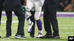 Minnesota Vikings running back Adrian Peterson (28) is helped off the field after getting injured during an NFL football game against the Green Bay Packers, Sept. 18, 2016.