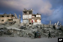 A antheral   pushes a cart past   a location   that remains partially  standing, but with sheets serving arsenic  makeshift walls, successful  an country  mostly  destroyed by the Israeli army's aerial  and crushed  violative  successful  Gaza City, Gaza Strip, Feb. 5, 2025.