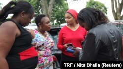 Female taxi drivers Julie Wahome, Lydia Muchiri, Faridah Khamis and Agnes Mwongara chat at a parking lot in Nairobi, April 19, 2018.