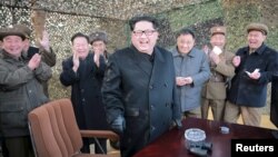 Pemimpin Korea Utara Kim Jong Un (tengah) bersama para petinggi militernya ketika ujicoba peluncuran misil Korut (4/3).