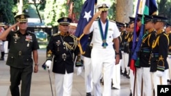 In this photo released by Public Affaires Office, Armed Forces of the Philippines, U.S. Adm. Samuel J. Locklear, third from left, commander of the U.S. Pacific Command, accompanied by Philippine Armed Forces Chief Gen. Gregorio Pio Catapang, left, salutes the colors during arrival honors, Oct. 14, 2014, at Camp Aguinaldo General Headquarters at suburban Quezon city northeast of Manila.