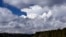 Storm clouds build prior to the arrival of a thunderstorm as Jeff Warren of Auburn, Maine, heads for shore on his paddleboard on Lower Range Pond Thursday, March 17, 2016, in Poland, Maine. (AP Photo/Robert F. Bukaty)