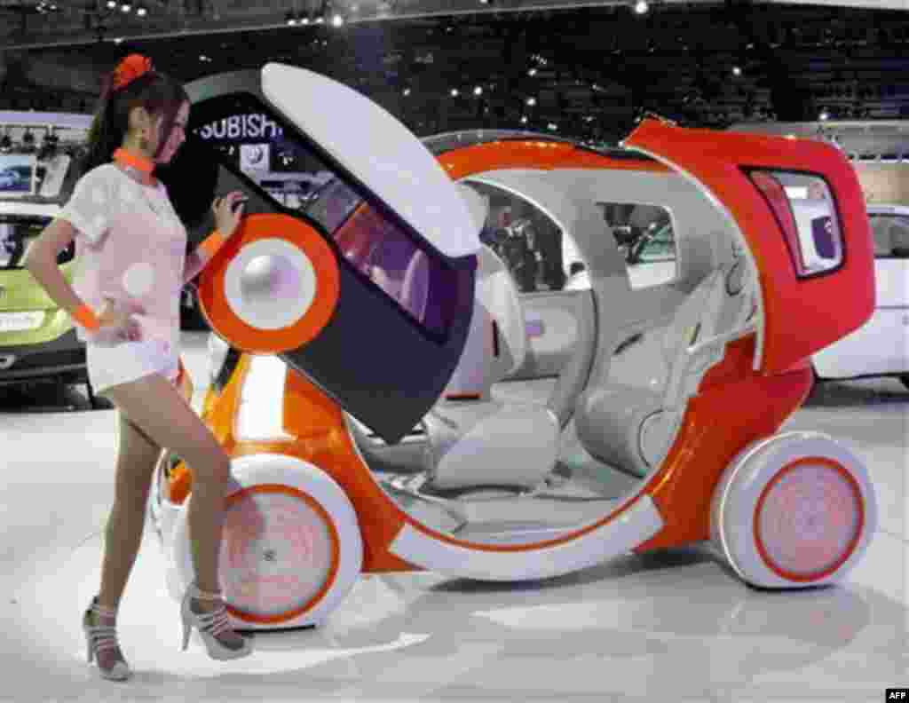 A model poses near Suzuki Motor Corp.,'s concept car "Q-Concept" during the press preview of Tokyo Motor Show in Tokyo, Wednesday, Nov. 30, 2011. The Tokyo Motor Show opens to the public this weekend. (AP Photo/Koji Sasahara)