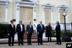 President Donald Trump stands outside St. John's Church, June 1, 2020, in Washington. Standing with Trump are Mark Esper, from left, William Barr, Robert O'Brien, Kayleigh McEnany and Mark Meadows.