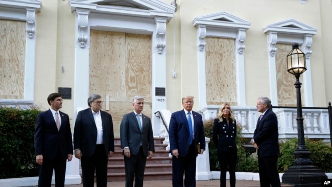 President Donald Trump stands outside St. John's Church, June 1, 2020, in Washington. Standing with Trump are Mark Esper, from left, William Barr, Robert O'Brien, Kayleigh McEnany and Mark Meadows.