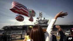 ARSIP – Dalam foto yang diambil tanggal 1 Oktober 2015, anggota keluarga para pelaut melambaikan tangan ke arah kapal induk AL AS, USS Ronald Reagan, yang tiba di pangkalan AL AS di Yokosuka, Jepang sebelah selatan Tokyo (foto: AP Photo/Eugene Hoshiko, Arsip)