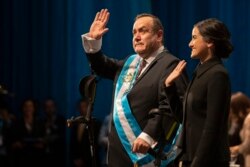 FILE - Alejandro Giammattei, accompanied by his daughter, Ana Marcela, waves to the crowd after he was sworn in as president of Guatemala at the National Theater in Guatemala City, Jan. 14, 2020.