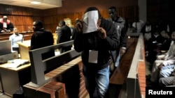 South African police officers arrested on suspicion of murder appear for bail hearing east of Johannesburg on March 11, 2013. Nine South African policemen pleaded not guilty to charges of murdering a Mozambican taxi driver who has handcuffed and dragged behind a police vehicle.