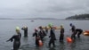 Swimmers enter the water for a mid-October, 1.6 km "excursion" at Alki Beach in Seattle. (VOA / T. Banse)