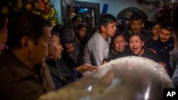 Familiares y amigos reaccionan cuando los cuerpos de Jair Valencia, Misael Olivares y Yovani Valencia llegan a la casa de su familia en San Marcos Atexquilapan, estado de Veracruz, México, el 13 de julio de 2022. 