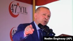 Le président turc Recep Tayyip Erdogan, parle avant un défilé militaire marquant le 47e anniversaire de l'invasion turque de 1974 à Nicosie, Chypre, mardi 20 juillet 2021. 