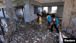 Anak-anak Yaman memeriksa gedung sekolah mereka yang hancur oleh serangan udara koalisi pimpinan Saudi di kota pelabuhan Hodeida, Yaman (foto: dok). 