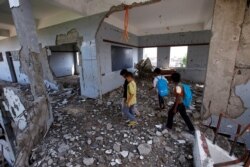 FILE - Boys walk in their school, damaged by a recent Saudi-led airstrike, in the Red Sea port city of Hodeida, Yemen, Oct. 24, 2017.