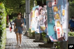 People walk past candidates' campaign flags in Taipei, Taiwan, Nov. 20, 2022. Taiwan will hold local elections on Nov. 26.