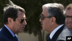 FILE - Cypriot President Nicos Anastasiades, left, and breakaway Turkish Cypriot leader Mustafa Akinci talk at the disused Nicosia airport inside a United Nations controlled buffer zone in this divided island of Cyprus, Sept. 14 2016. The leaders have agreed to conduct a key phase of reunification talks, a U.N. spokesman said.