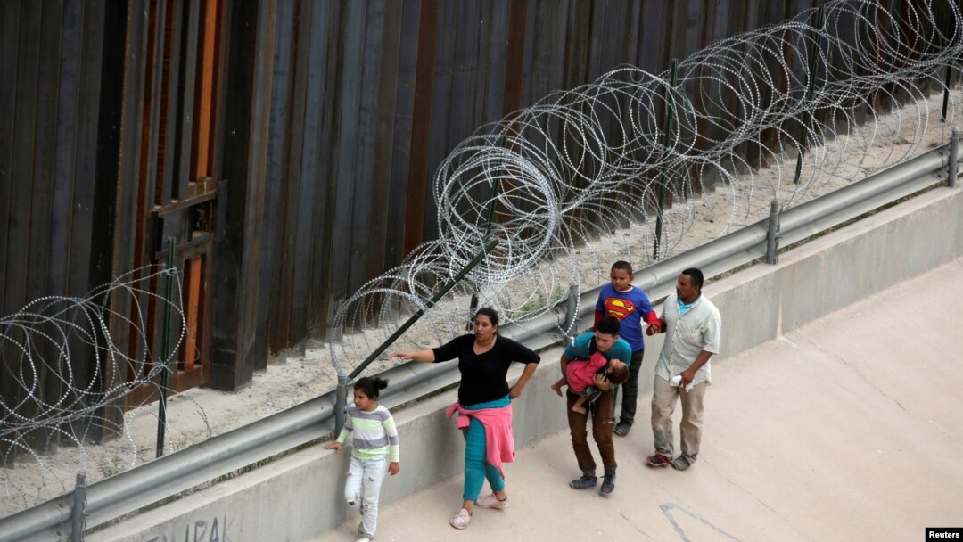 Migrantes caminan a lo largo del muro fronterizo tras cruzar ilegalmente por el El Paso, Texas, desde Ciudad Juárez, México, el 17 de julio de 2019.