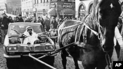Ноябрь 1973 года. ФРГ, город Нюрнберг. Реакция на нефтяное эмбарго. Мужчина, одетый как арабский шейх, управляет лошадью, запряженную в его автомобиль.