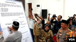 Forum Komunikasi Pimpinan Daerah Kota Surabaya menandatangani pernyataan sikap tidak takut melawan intoleransi, radikalisme dan terorisme, serta jogo Suroboyo, di Mapolrestabes Surabaya, Selasa (14/5). (Foto: VOA/Petrus)