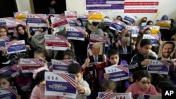 FILE - Afghan refugees hold placards during their meeting to discuss situation after President Donald Trump paused the US refugee programs, in Islamabad, Pakistan, Jan. 24, 2025.