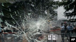 Police officers stand guard near a broken glass outside Legislative Council building in Hong Kong, July 2, 2019.