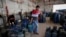 In this Thursday, Jan. 7, 2016 photo, a Palestinian worker carries a gas canister filled only by half, as other bottles wait to be filled at the main gas station in Jebaliya, Gaza Strip. Gas used for heating and cooking in Gaza is in short supply because 