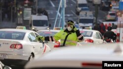 FILE - Due to air pollution in Madrid, a traffic policeman wears a mask while directing traffic, Dec. 29, 2016.