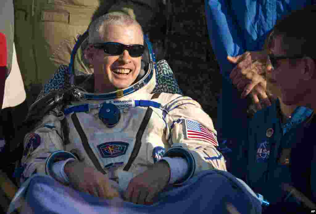 Astronaut Steve Swanson of NASA rests outside the Soyuz Capsule, Kazakhstan, Sept. 11, 2014.