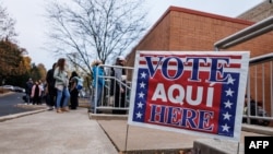 Para pemilih mengantre di luar tempat pemungutan suara di Sekolah Dasar Donegan saat pemungutan suara dibuka pada hari pemilihan di Bethlehem, Pennsylvania pada 5 November 2024. (Foto: SAMUEL CORUM/AFP)