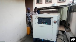 A worker inspects a generator used by Nature's Treat Cafe in Ibadan, Nigeria, May 27, 2024. Households and businesses often use polluting gasoline and diesel generators. But as fuel prices rise, businesses face higher costs, prompting a push for affordable solar solutions.