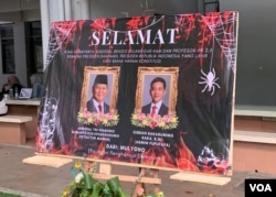 Karangan bunga pelantikan presiden dan wakil presiden baru yang dipasang di taman FISIP (foto Petrus Riski/VOA)