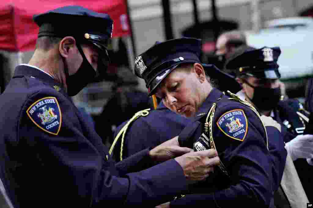 دو پلیس که برای شرکت در مراسم یادبود قربانیان حمله تروریستی ۱۱ سپتامبر ۲۰۰۱ در منطقه منهتن شهر نیویورک آماده می‌شوند.