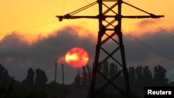 FILE - An electricity transmission tower is seen on the outskirts of the town of Lozova, some 450 km (280 miles) east of Ukraine's capital Kyiv, Aug. 28, 2008. Ukraine is investigating a suspected cyberattack on Kyiv's power grid over the weekend.