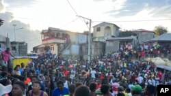 La gente observa los esfuerzos de rescate en las casas que se derrumbaron después de un terremoto en Jeremie, Haití, el martes 6 de junio de 2023.